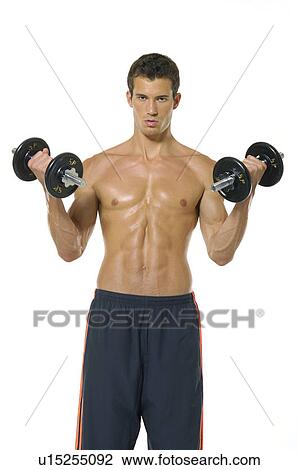 Stock Image - Portrait of a young man exercising with dumbbells. Fotosearch