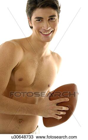 Stock Image - Portrait of a young man playing with a rugby ball. Fotosearch
