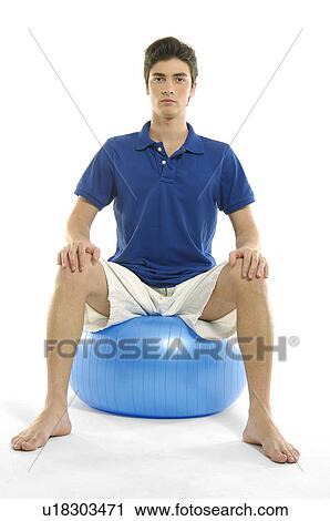 Portrait of a young man sitting on a fitness ball View Large Photo Image Stock Image - Portrait of a young man sitting on a fitness ball. Fotosearch