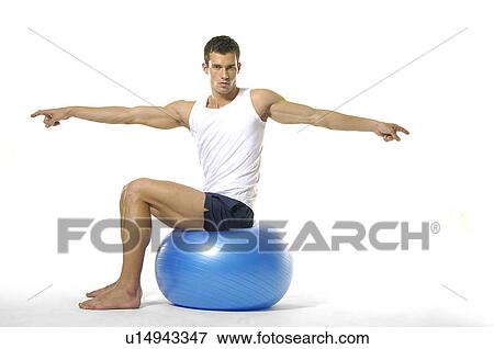 Portrait of a young man sitting on a fitness ball and exercising View Large Photo Image Stock Photo - Portrait of a young man sitting on a fitness ball and exercising. Fotosearch