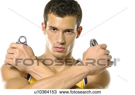 Portrait of a young man squeezing handgrips View Large Photo Image Stock Image - Portrait of a young man squeezing handgrips. Fotosearch