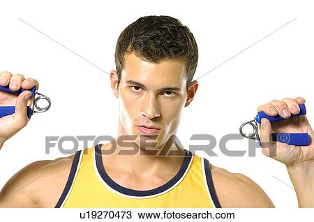 Portrait of a young man squeezing handgrips View Large Photo Image Stock Image - Portrait of a young man squeezing handgrips. Fotosearch