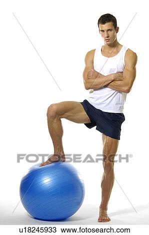 Portrait of a young man standing with his leg on a fitness ball View Large Photo Image Stock Image - Portrait of a young man standing with his leg on a fitness ball. Fotosearch