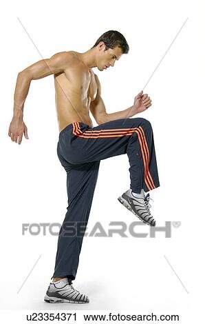 Side profile of a young man stretching his leg View Large Photo Image Stock Image - Side profile of a young man stretching his leg. Fotosearch