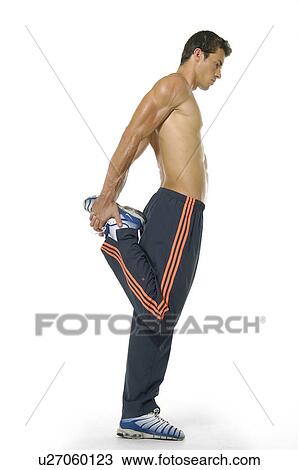 Side profile of a young man stretching his leg View Large Photo Image Stock Image - Side profile of a young man stretching his leg. Fotosearch