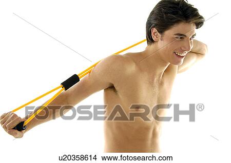 Young man exercising with a resistance band and smiling View Large Photo Image Picture - Young man exercising with a resistance band and smiling. Fotosearch