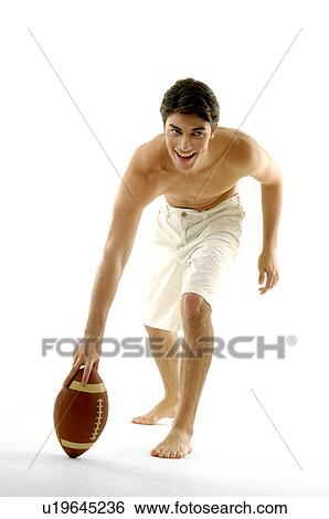 Stock Photograph - Young man playing with a rugby ball. Fotosearch