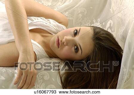Portrait of a young woman lying on a couch View Large Photo Image Stock Image - Portrait of a young woman lying on a couch. Fotosearch
