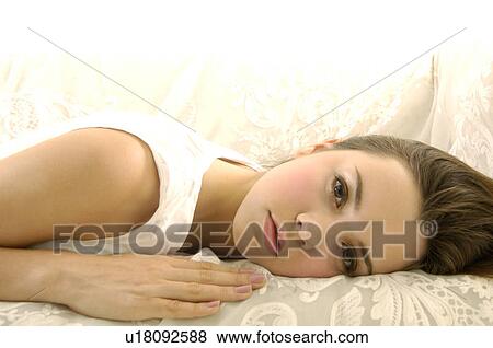 Portrait of a young woman lying on a couch View Large Photo Image Stock Photo - Portrait of a young woman lying on a couch. Fotosearch