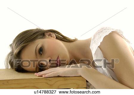 Portrait of a young woman resting her head on a stool View Large Photo Image Stock Photo - Portrait of a young woman resting her head on a stool. Fotosearch