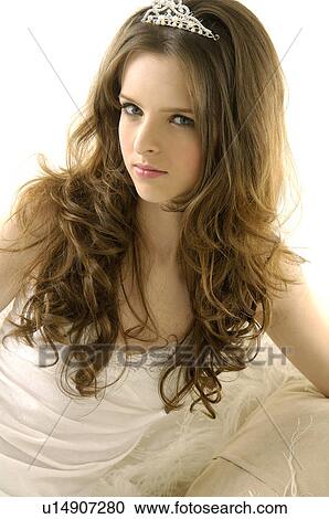 Portrait of a young woman sitting on a couch and wearing a tiara View Large Photo Image Stock Image - Portrait of a young woman sitting on a couch and wearing a tiara. Fotosearch