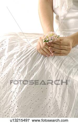 Stock Photo - Mid section view of a woman holding a flower. Fotosearch