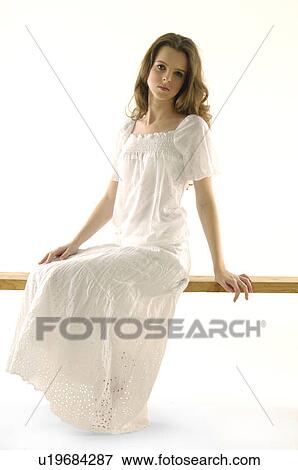 Portrait of a young woman sitting on a bench View Large Photo Image Stock Photo - Portrait of a young woman sitting on a bench. Fotosearch