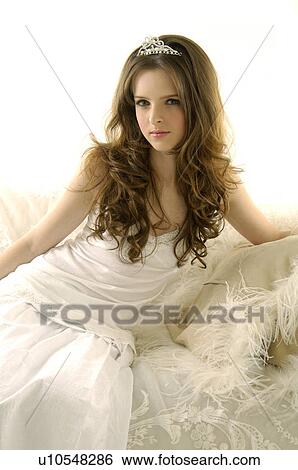 Portrait of a young woman sitting on a couch View Large Photo Image Stock Photograph - Portrait of a young woman sitting on a couch. Fotosearch