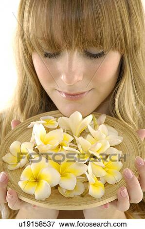 Close-up of a young woman holding flowers View Large Photo Image Stock Photo - Close-up of a young woman holding flowers. Fotosearch