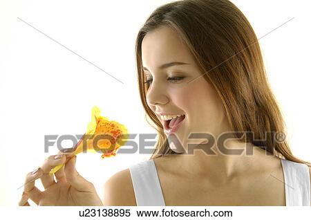 Close-up of a young woman smiling and holding a flower View Large Photo Image Stock Photography - Close-up of a young woman smiling and holding a flower. Fotosearch