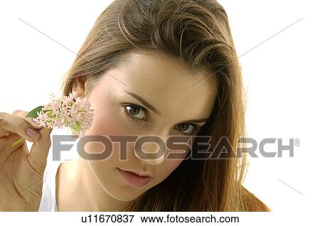 Portrait of a young woman holding a flower View Large Photo Image Stock Photo - Portrait of a young woman holding a flower. Fotosearch