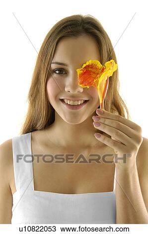 Portrait of a young woman smiling and holding a flower View Large Photo Image Stock Image - Portrait of a young woman smiling and holding a flower. Fotosearch