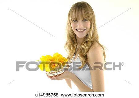 Portrait of a young woman smiling and holding flowers View Large Photo Image Stock Photo - Portrait of a young woman smiling and holding flowers. Fotosearch