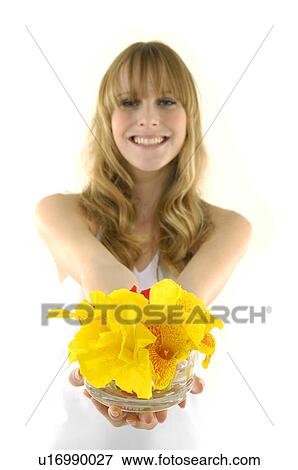 Portrait of a young woman smiling and holding flowers View Large Photo Image Stock Photo - Portrait of a young woman smiling and holding flowers. Fotosearch
