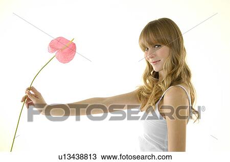 Side profile of a young woman holding a flower View Large Photo Image Stock Image - Side profile of a young woman holding a flower. Fotosearch
