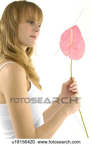 Side profile of a young woman holding a flower View Large Photo Image Stock Image - Side profile of a young woman holding a flower. Fotosearch