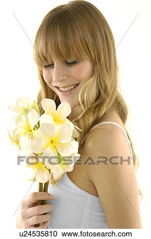 Side profile of a young woman smiling and holding flowers View Large Photo Image Stock Image - Side profile of a young woman smiling and holding flowers. Fotosearch