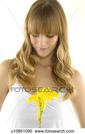 Young woman holding a flower View Large Photo Image Stock Image - Young woman holding a flower. Fotosearch