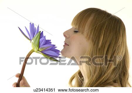 サイドプロフィール の A 若い女性 花のにおいをかぐ ストックイメージ U Fotosearch