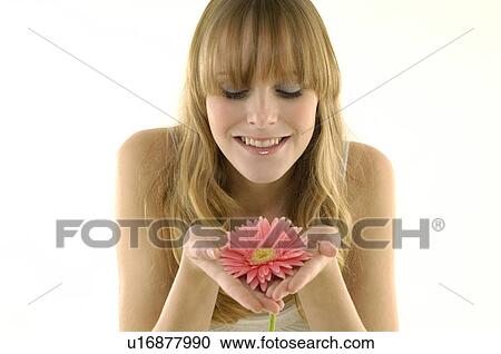 Stock Image - Close-up of a young woman holding a flower. Fotosearch