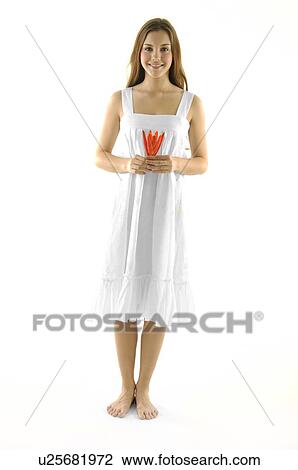 Stock Image - Portrait of a young woman holding a flower and smiling. Fotosearch