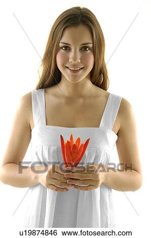 Stock Photograph - Portrait of a young woman holding a flower. Fotosearch