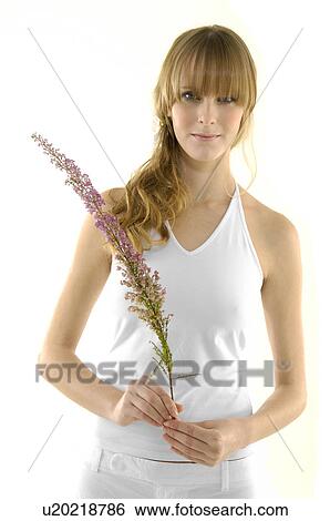 Portrait of a young woman holding a flower View Large Photo Image Stock Photograph - Portrait of a young woman holding a flower. Fotosearch