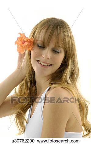 Side profile of a young woman holding a flower View Large Photo Image Stock Image - Side profile of a young woman holding a flower. Fotosearch