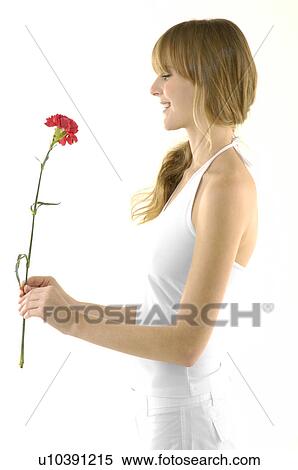 Side profile of a young woman holding a flower View Large Photo Image Stock Photography - Side profile of a young woman holding a flower. Fotosearch