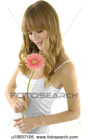 Stock Photography - Side profile of a young woman holding a flower. Fotosearch