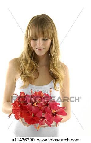 Stock Image - Young woman holding a flower pot. Fotosearch