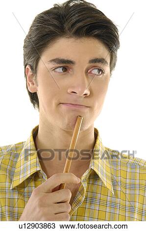 Close-up of a young man holding a pencil and thinking View Large Photo Image Stock Image - Close-up of a young man holding a pencil and thinking. Fotosearch