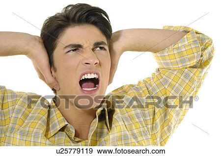 Close-up of a young man shouting with his hands covering his ears View Large Photo Image Stock Photo - Close-up of a young man shouting with his hands covering his ears. Fotosearch