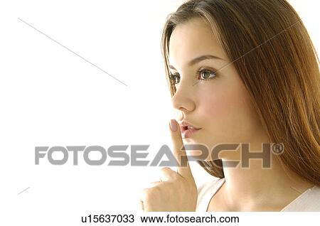 Close-up of a young woman with her finger on her lips View Large Photo Image Stock Image - Close-up of a young woman with her finger on her lips. Fotosearch