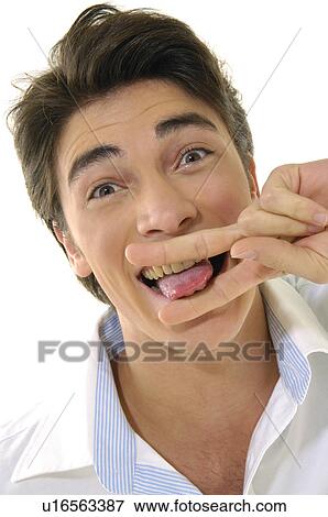 Portrait of a young man pretending to cut his tongue with his fingers View Large Photo Image Stock Photo - Portrait of a young man pretending to cut his tongue with his fingers. Fotosearch