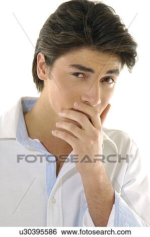 Portrait of a young man with his hands covering mouth View Large Photo Image Stock Photograph - Portrait of a young man with his hands covering mouth. Fotosearch