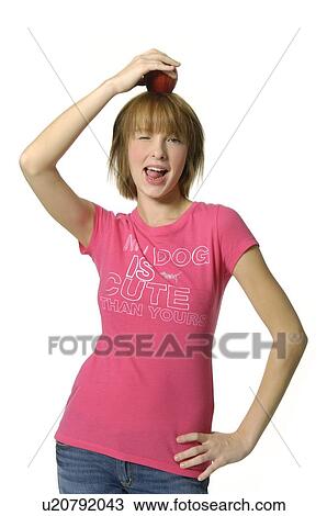 Portrait of a young woman holding an apple on her head View Large Photo Image Stock Image - Portrait of a young woman holding an apple on her head. Fotosearch