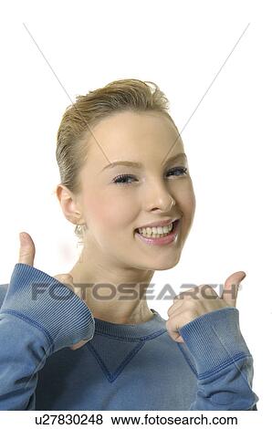 Stock Photo - Portrait of a young woman making thumbs up sign and smiling. Fotosearch
