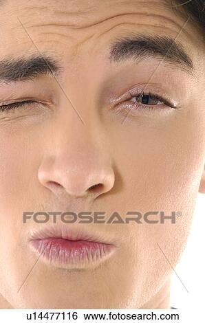 Close-up of a young man winking View Large Photo Image Stock Photograph - Close-up of a young man winking. Fotosearch