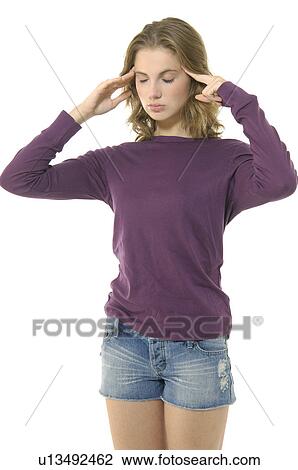 Stock Image - Close-up of a young woman suffering from a headache. Fotosearch
