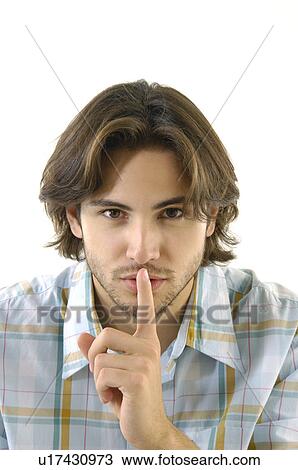 Portrait of a young man with his finger on his lips View Large Photo Image Stock Image - Portrait of a young man with his finger on his lips. Fotosearch