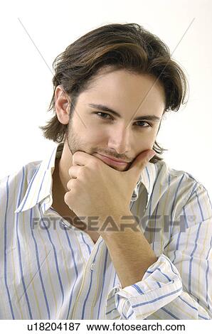 Stock Photo - Portrait of a young man with his hand on his chin. Fotosearch