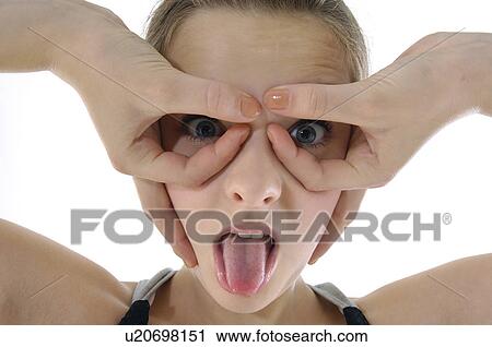 Stock Image - Portrait of a young woman pretending to wear glasses. Fotosearch