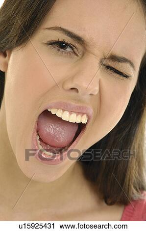 Stock Image - Portrait of a young woman winking. Fotosearch